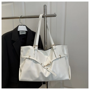 Detailed view of white large tote bag with elegant gold buckle and smooth leather finish