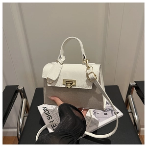 Detail view of contrast stitch square bag with textured pebble leather and metal clasp buckle