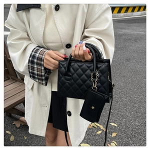 Détail du sac matelassé noir avec porte-monnaie à chaîne dorée et doubles poignées chic