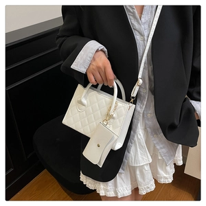 Détail du sac à bandoulière matelassé blanc avec mini pochette assortie et métal doré