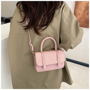 Model view showing the pink messenger bag with woven texture worn as a crossbody bag