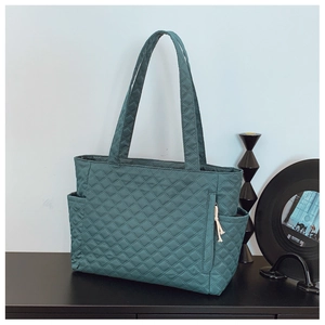 Close-up of diamond quilted tote bag with side pockets and white drawstring zip puller