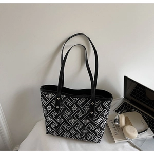 Detail of floral embroidery and silver rivets on a chic black tote bag for women
