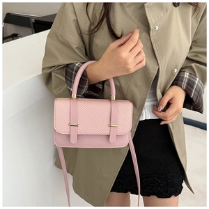 Close-up of pink leather handbag with woven texture and gold metal hardware