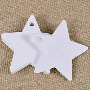 Close-up of star-shaped white paper gift tags with pre-punched holes on linen background