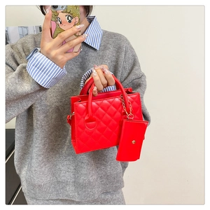 Détail du sac à main rouge en similicuir matelassé avec mini pochette et poignée ronde