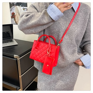 Détail du sac matelassé rouge avec mini pochette assortie et poignées rondes