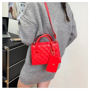 Détail du sac à bandoulière matelassé rouge avec mini porte-monnaie et chaîne dorée