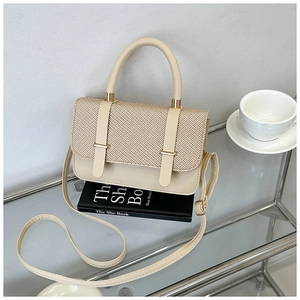 Detail of contrast stitching and woven straw flap on cream leather messenger handbag