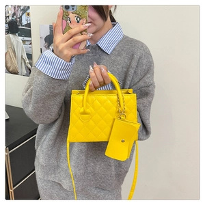 Détail d'un sac bandoulière matelassé jaune vif avec mini porte-monnaie et bandoulière en cuir