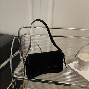 Chic black underarm bag with unique wavy flap design and slim leather shoulder strap