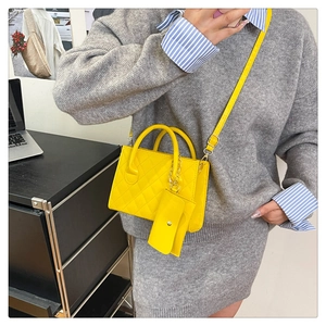 Gros plan sur un sac bandoulière matelassé jaune vif avec mini pochette assortie
