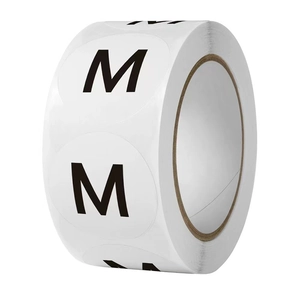 White round adhesive size M labels roll for clothing and packaging on white background