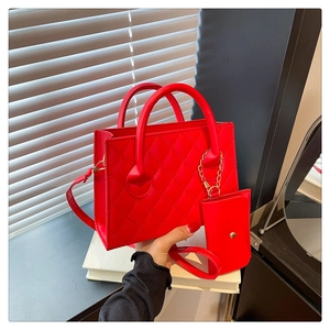 Détail d'un sac à main rouge matelassé avec petit porte-monnaie assorti et doubles poignées