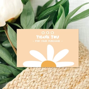 Pink floral Thank You card with daisy for gift packaging shown with fresh green leaves