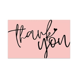 Close-up of pink rectangle thank you card with elegant black script and heart detail
