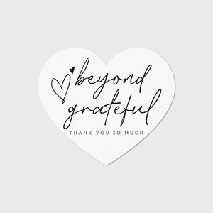Macro shot of minimalist heart-shaped thank you card with beyond grateful script and text