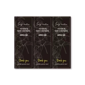 Detail of black rectangular waterproof labels with gold foil floral patterns and text