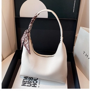 Détail du sac hobo en cuir grainé blanc avec foulard décoratif en soie marron imprimé