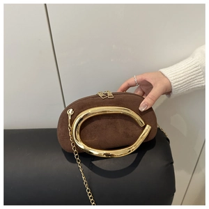 Detailed view of brown suede mini bag featuring a chunky gold metal handle and fine chain