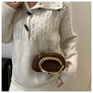 Close-up of brown suede mini bag with large gold metal ring and chain shoulder strap