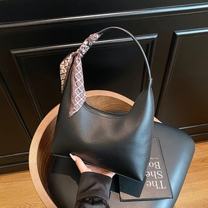 Black half-moon hobo shoulder bag featuring a patterned decorative silk scarf handle