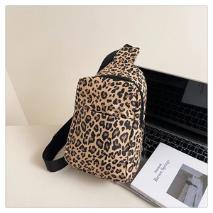 Leopard print crossbody chest bag shown next to a laptop in a minimalist office setting