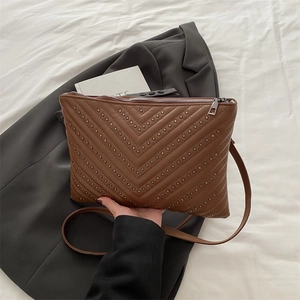 Caramel brown V-quilted faux leather crossbody bag with decorative silver rivets