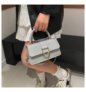 Detail of light blue handbag with shimmering rhinestone flap and golden D-shaped clasp