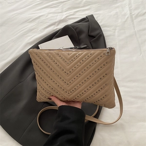 Beige quilted envelope bag with metallic studs and chain strap in minimalist chic style