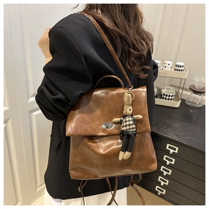 Detail of vintage brown leather backpack with metal twist lock and cute bunny charm