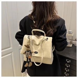 Detail of a creamy white PU leather backpack with twist lock and cute rabbit charm