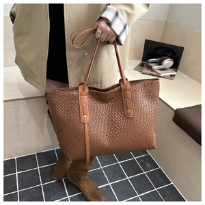 Detail of brown woven faux leather tote bag with long side straps for daily commute