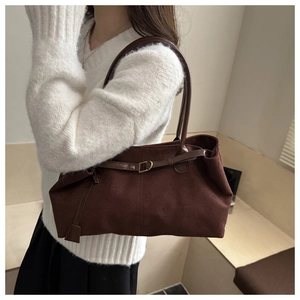 Detailed shot of dark brown matte leather tote bag featuring golden buckle and tassel