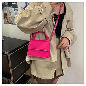 Detail of rose pink crossbody square bag with unique knotted top handle and flap closure