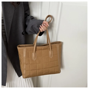 Detail of khaki quilted tote bag with square stitching and slim shoulder straps