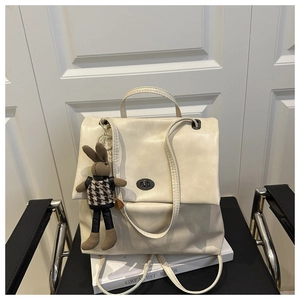 Detail of cream tote bag with gun-metal turn lock and cute rabbit plush charm