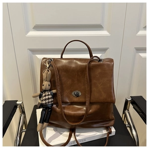 Detailed view of vintage brown backpack with metal twist lock and cute rabbit charm