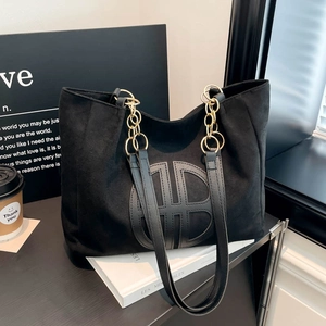 Large black suede tote bag with geometric logo and gold chain strap for casual commute