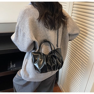 Détail du sac nuage plissé noir brillant avec finition texturée et fine bandoulière