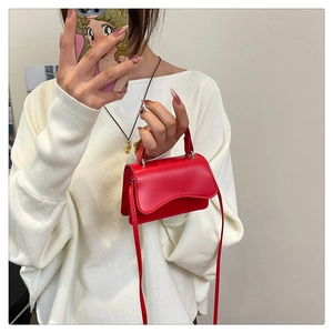 Détail du mini sac bandoulière rouge mat avec bandoulière réglable porté par un mannequin