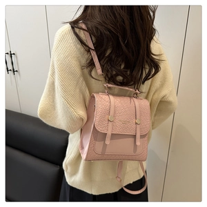 Detail of pink backpack featuring faux crocodile texture flap and versatile straps