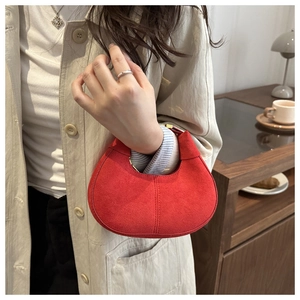 Detail of red frosted hobo bag with vertical stitching and elegant curved silhouette