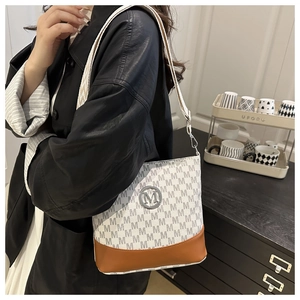Close-up of small crossbody bag with letter print pattern and metal logo detail