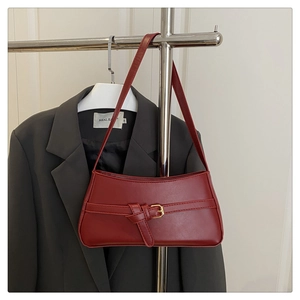 Detailed view of the dark red underarm bag with decorative metal buckle and PU leather texture
