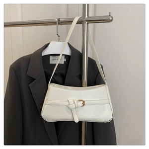Detail of cream white PU leather underarm bag with buckle on dark grey blazer
