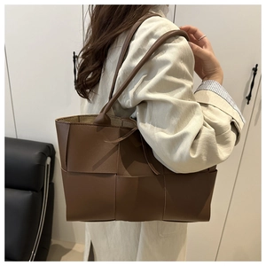 Brown woven leather tote bag shown on a model's shoulder for casual everyday style