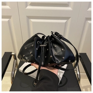Close-up of black PU leather bucket bag featuring silver rivet studs and drawstring closure