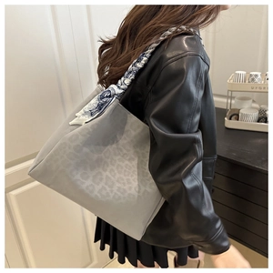 Detail of grey leopard print tote bag with decorative silk scarf on the handle