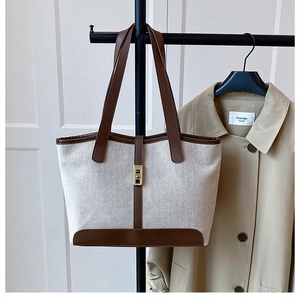 Détail du sac cabas rétro en toile avec garniture en cuir brun et fermoir doré